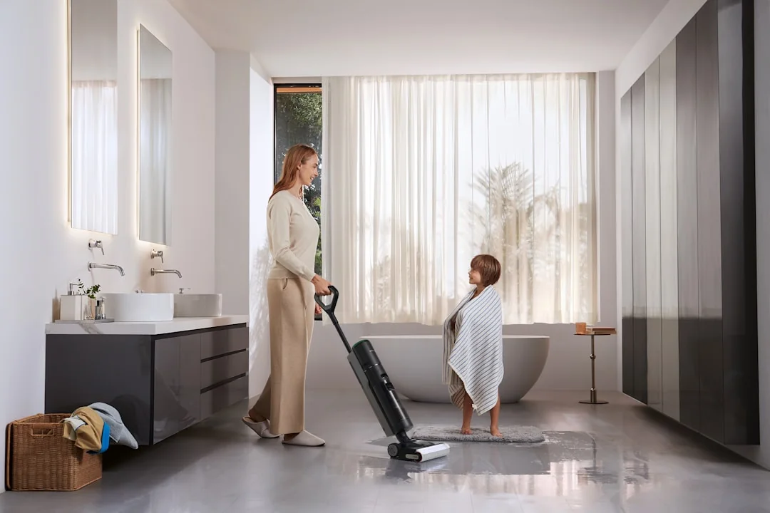 A professional housekeeper organizing pillows in a luxurious hotel room, maintaining service quality.